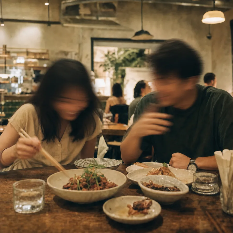 An Asian pair laughing over several shared dishes at an independent restaurant.
